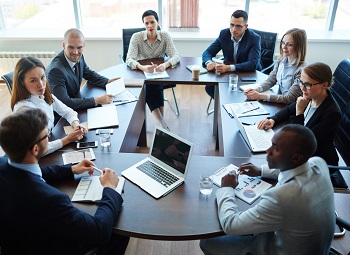 Several office workers sitting around a table for a meeting